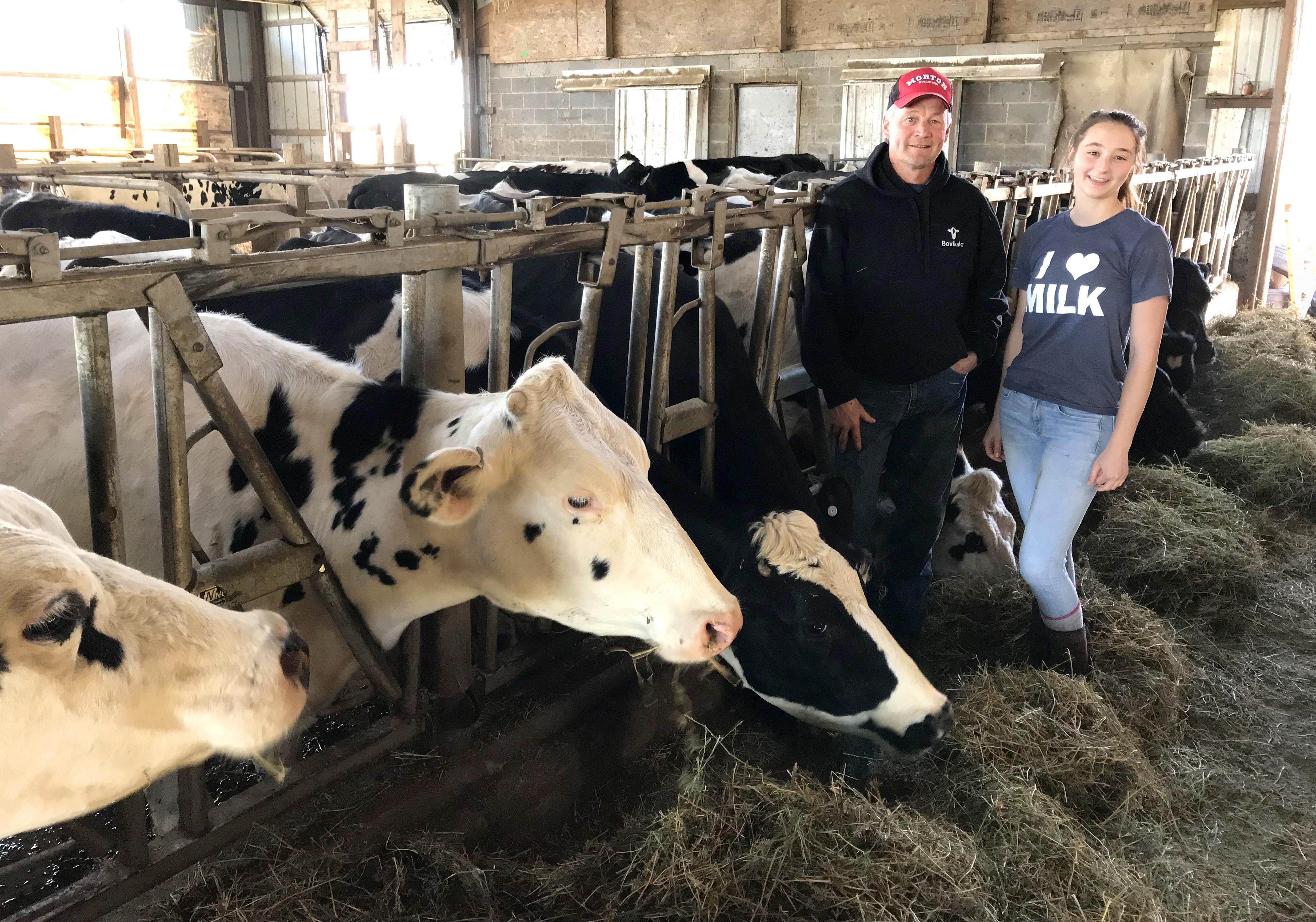 farmers pose next to cattle grazing