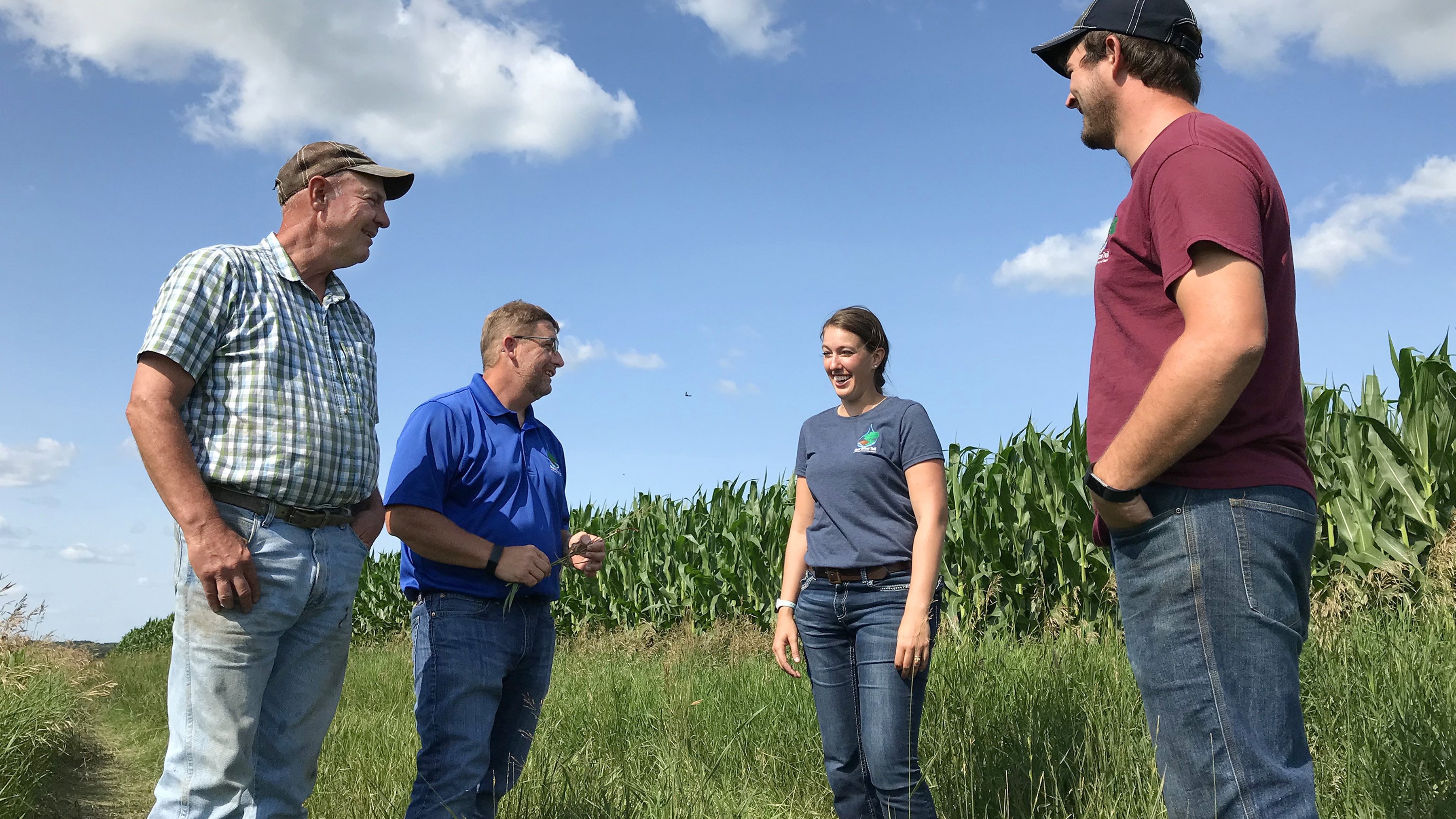 Landowner Mark Riestenberg and East Otter Tail SWCD staff talk at the edge of an irrigated corn field