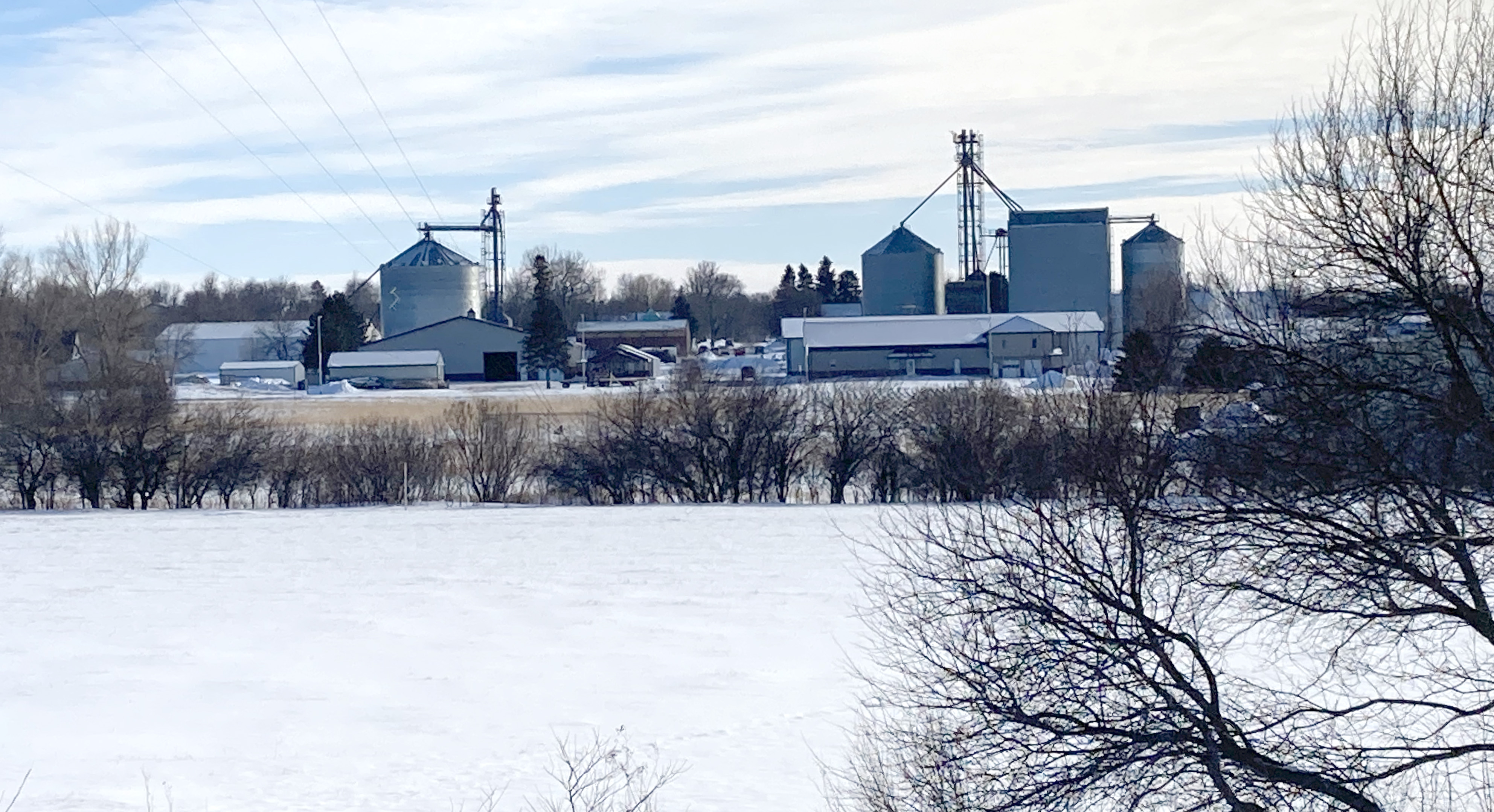 Snow covers a wellhead protection area. Adrian skyline is in the background.