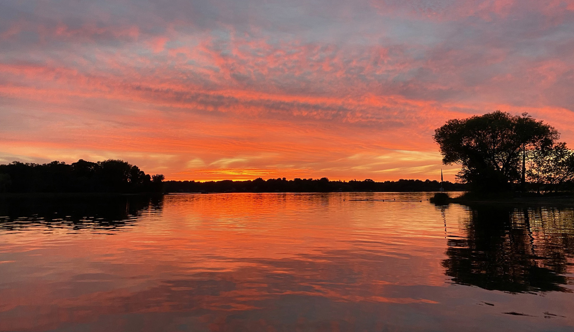 Clouds and sun reflect orange and pink in North Center Lake