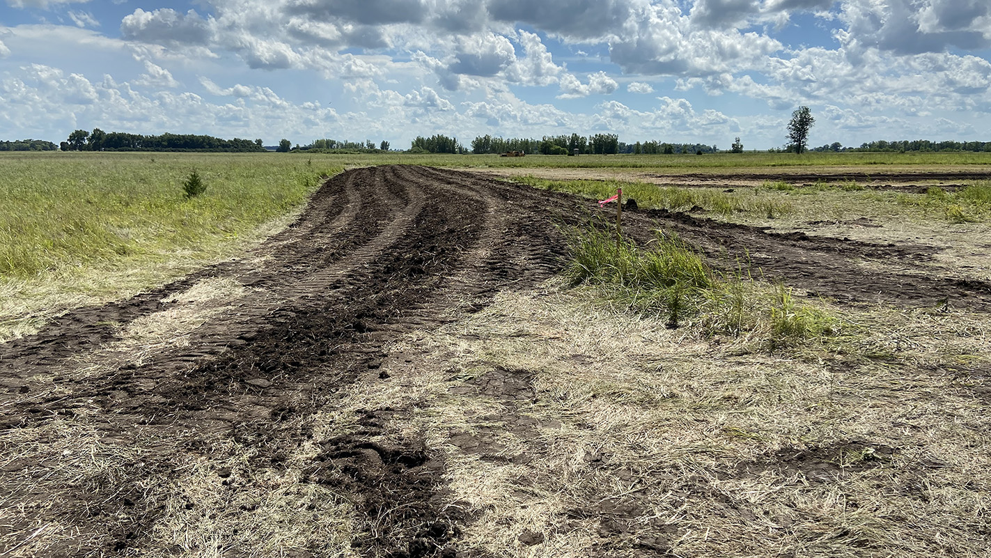 Black soil indicates where a berm is being constructed