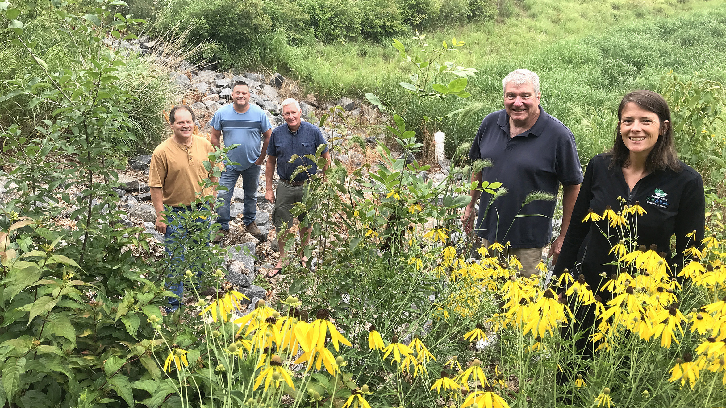 Yellow flowers frame a group of five people