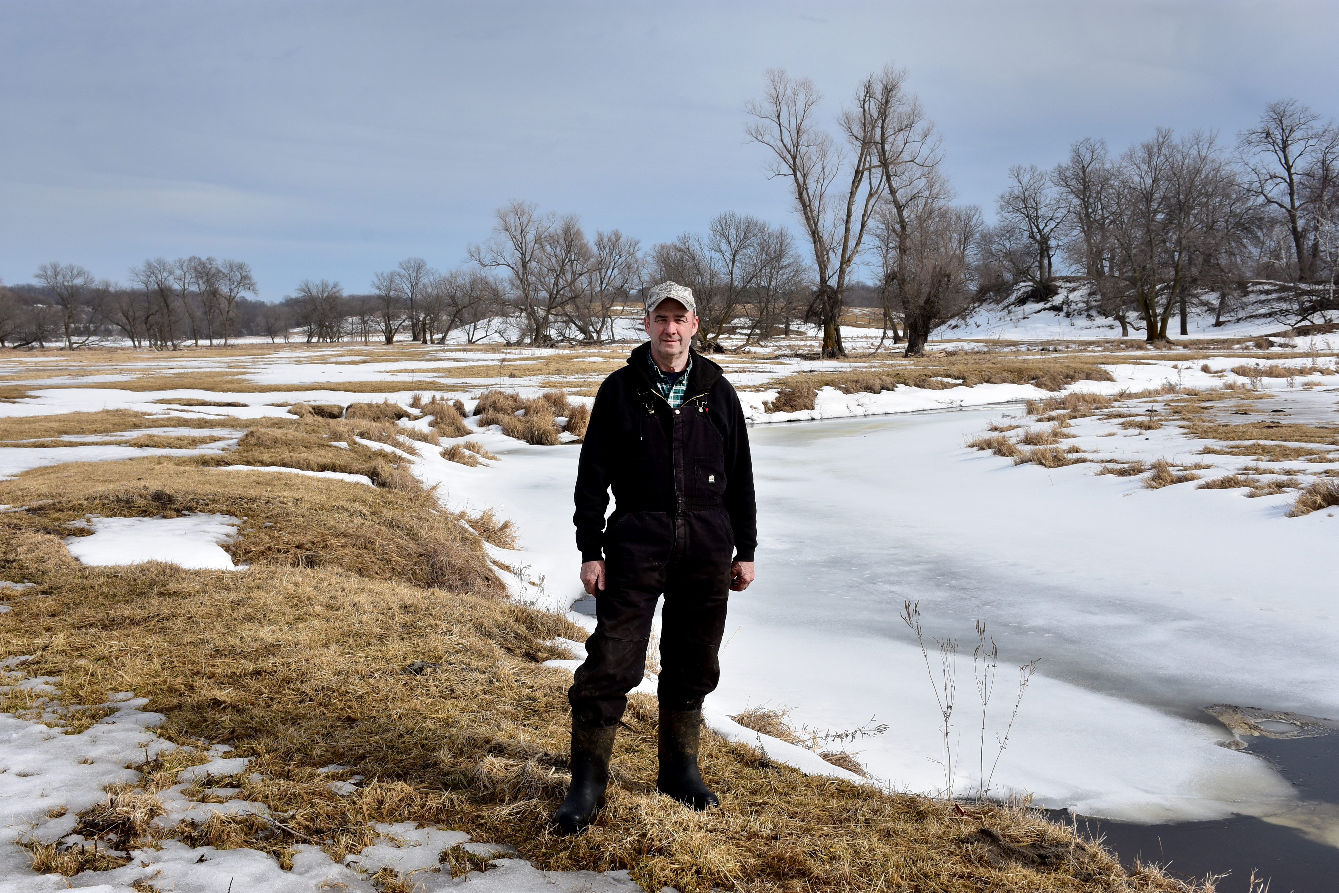 Man stands at the bend of a frozen river