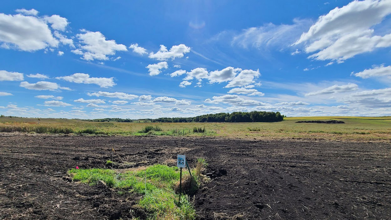 A Reinvest in Minnesota sign stands in a patch of grass
