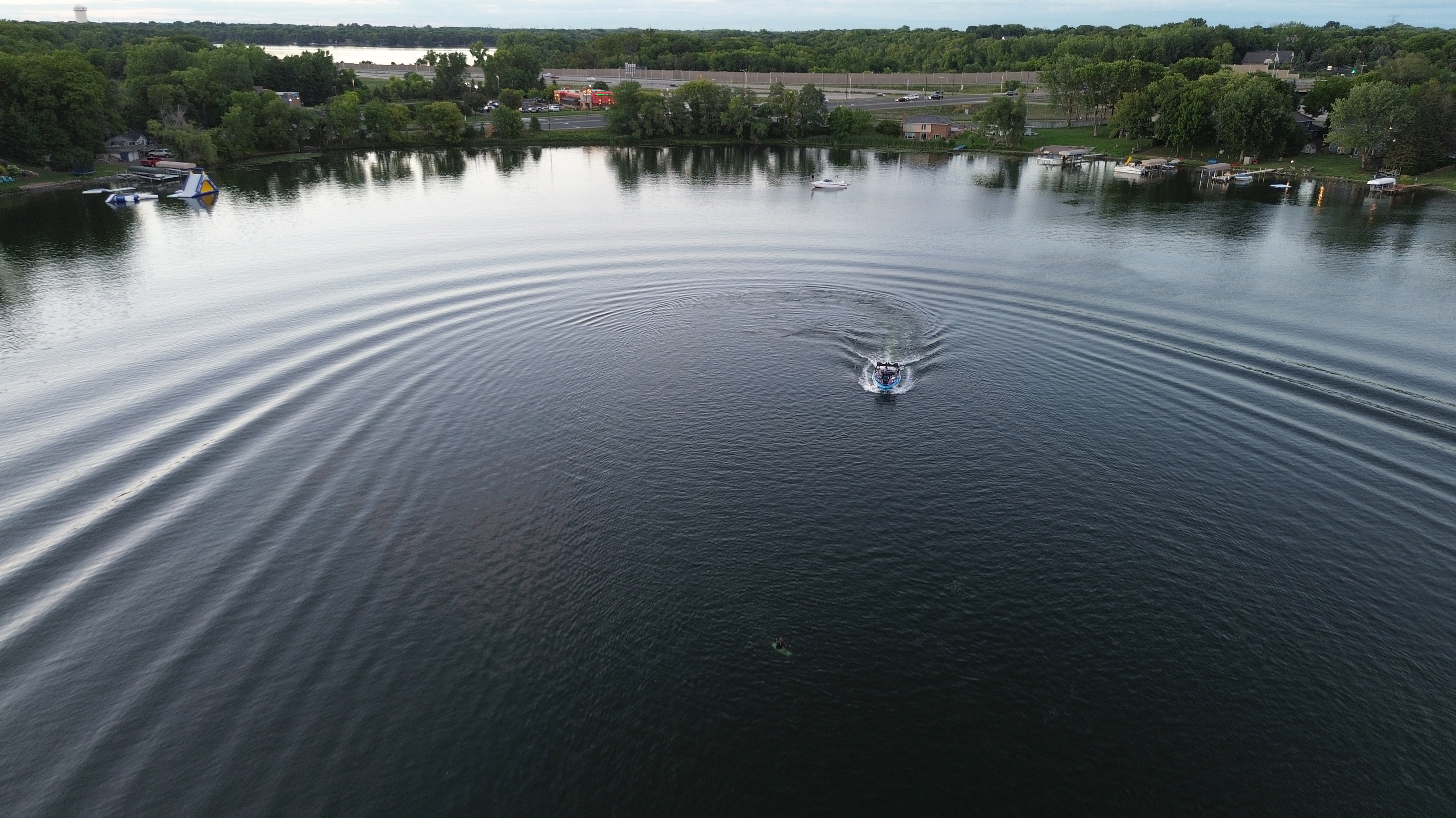 An aerial view of a boat crossing a lake