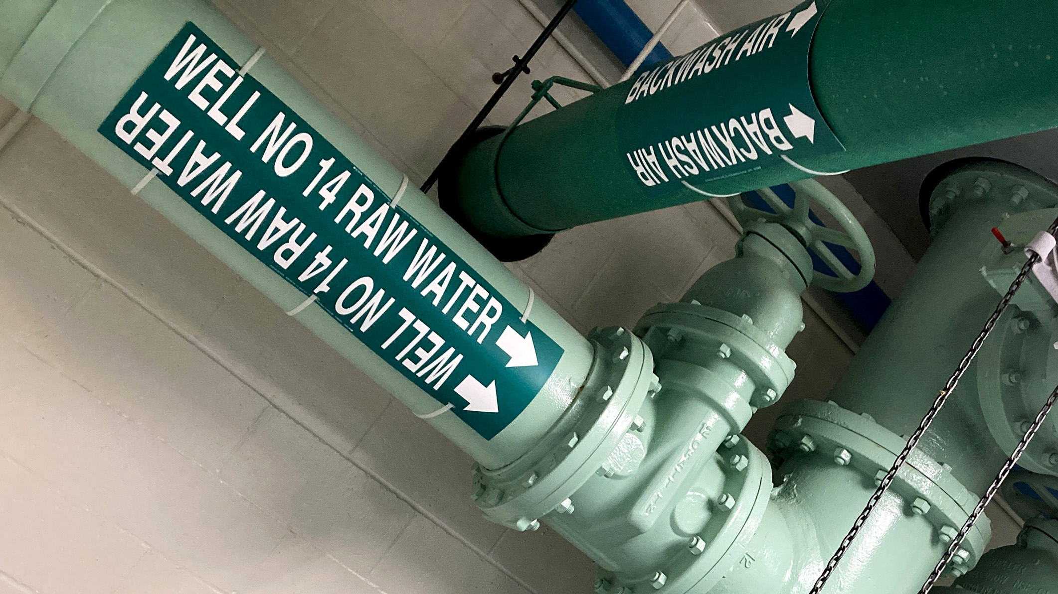 large pipes painted green and labeled Well No. 14 Raw Water