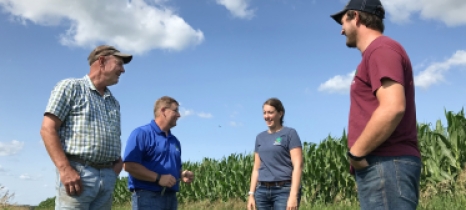 Landowner Mark Riestenberg and East Otter Tail SWCD staff talk at the edge of an irrigated corn field