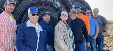 people standing in front of farm equipment