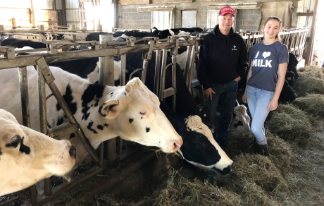 farmers pose next to cattle grazing