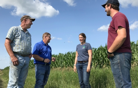 Landowner Mark Riestenberg and East Otter Tail SWCD staff talk at the edge of an irrigated corn field