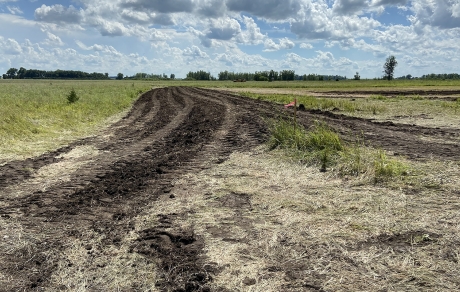 Black soil indicates where a berm is being constructed