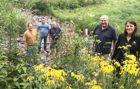 Yellow flowers frame a group of five people