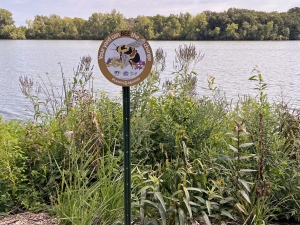 A L2L sign in a garden near a body of water