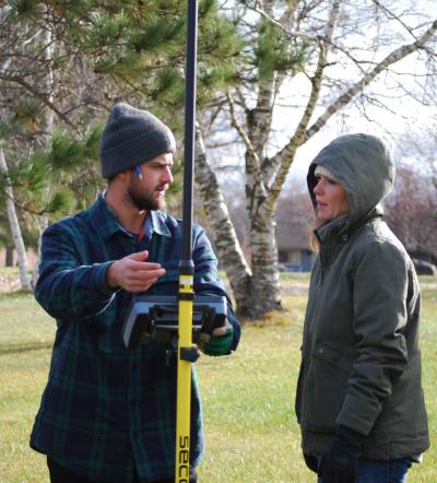 Image of individuals using survey equipment