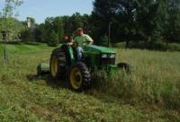 Tractor mowing native grass and forb planting